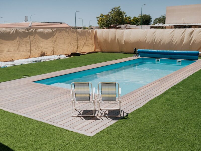 בריכת שחייה, שתי כיסאות ודשא מסביב