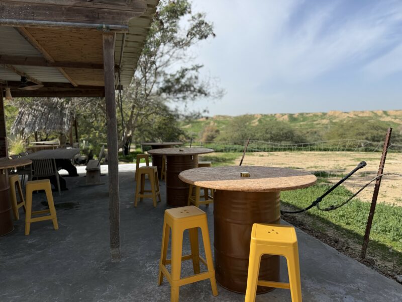 כיסאות ושולחן בר גבוהים על רקע שדות