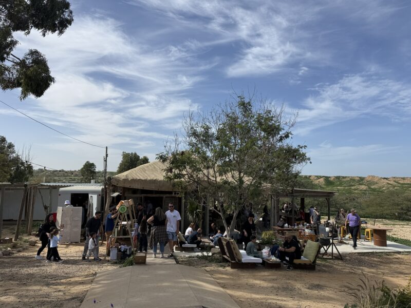 אזור עם צילייה עץ ופינות ישיבה ואנשים מסתובבים