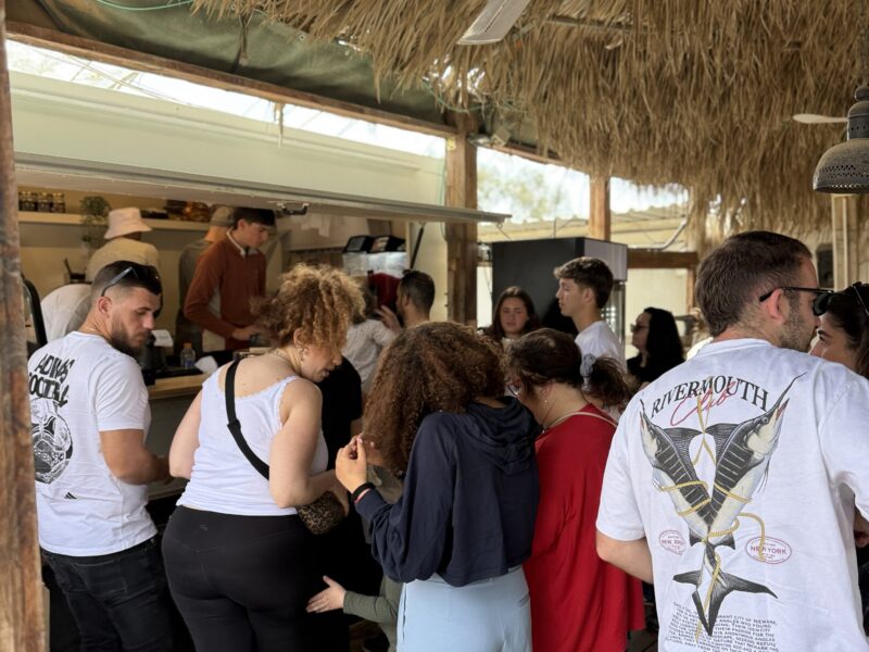 אנשים עומדים בתור להזמנה בעגלת קפה