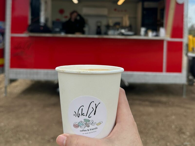 כוס קפה מקרטון על רקע עגלת קפה