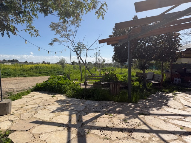 רחבה חיצונית עם רצפת אבן פונה לכיוון השדות