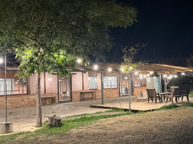 מבנה מעוצב באווירה כפרית ופינת ישיבה חיצונית באזור מקורה