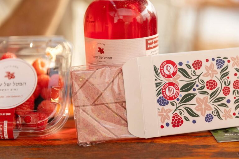 קופסא עם פטל, בקבוק מיץ, ומארז שוקולד