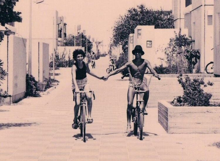 תמונה ישנה של זוג על אופניים מחזיק ידיים